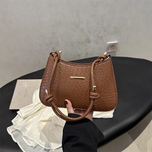 Brown crocodile pattern underarm bag with gold metal trim and unique knot strap detail