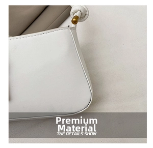 Close-up of white leather handbag featuring fine stitching and gold metal knot details