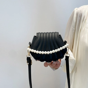 Sac bandoulière noir en forme de coquillage avec texture matelassée et perles blanches