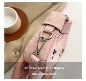 Détails d'un sac rose avec texture pierre, anneau en D argenté et fermeture éclair de près