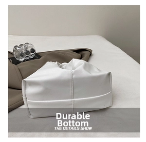 Gros plan du fond résistant avec coutures renforcées sur un sac à main en cuir blanc élégant
