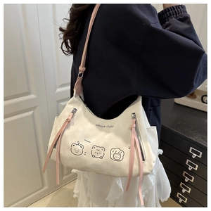 Close-up of cream tote bag featuring cute cartoon bears and pink shoulder straps