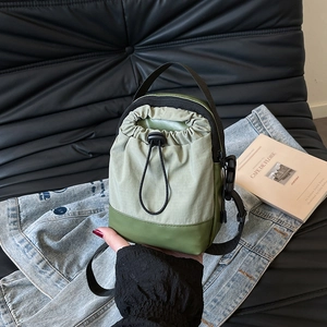 Lightweight green nylon drawstring mini crossbody bag with adjustable black shoulder strap