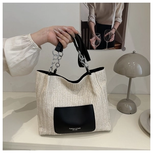 Detailaufnahme der Stroh-Einkaufstasche mit schwarzer Ledertasche und Metallketten-Griff