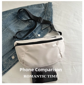 Water-resistant cream sling bag shown with smartphone for scale comparison