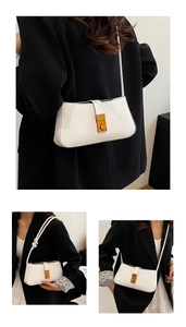 Detail view of the elegant golden clasp and fine shoulder strap on the white shoulder bag