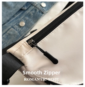 Detailed close-up of smooth black zipper and strap on white waterproof nylon chest bag
