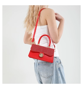 Detail of red sequined flap handbag with gold clasp shown on a crossbody model