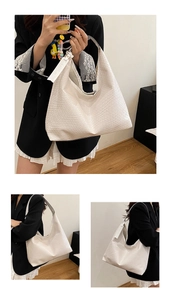 Close-up of cream woven texture and FASHION tag on a large capacity tote shoulder bag