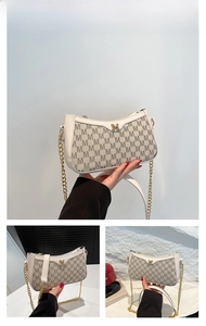 Detail of white monogram shoulder bag featuring gold chain strap and metal M logo buckle