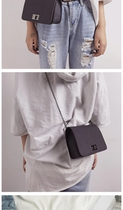 Detail of dark grey rectangular crossbody bag with metal twist lock and chain strap