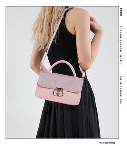 Pink crossbody bag with sequined flap and gold ring lock worn by model on black dress