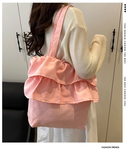 Detailed side view of pink tote bag featuring triple-layered ruffle pleats on fabric
