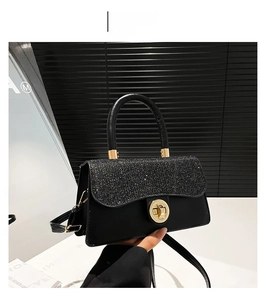 Détail du rabat à paillettes noires brillantes avec fermoir rotatif doré sur le sac à main