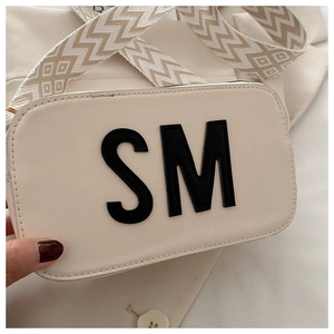 Détail du sac à bandoulière blanc crème avec large sangle jacquard et broderie de lettre SM