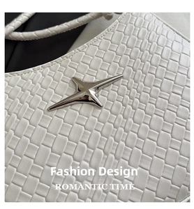 Detail of white woven texture leather bag with a polished silver star metal ornament