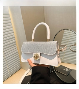 Détail du sac à main blanc avec rabat couvert de strass et fermoir rotatif en métal