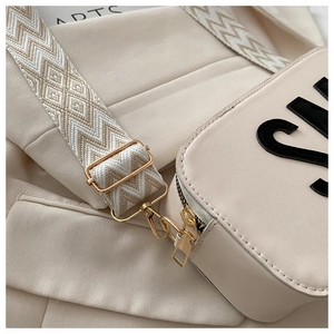 Détail du sac beige avec large bandoulière tissée aux motifs géométriques stylés