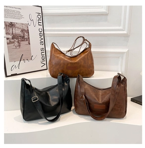 Three elegant hobo shoulder bags in brown, black, and dark coffee on a stylish display