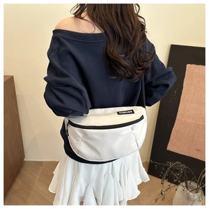Rear view of model wearing a white crescent nylon crossbody bag with black zipper