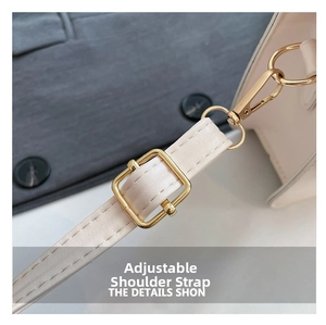 Detail of adjustable PU leather strap with golden metal buckle on beige crossbody bag