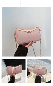 Detail of pink shoulder bag with fine texture, gold chain and metallic letter M logo
