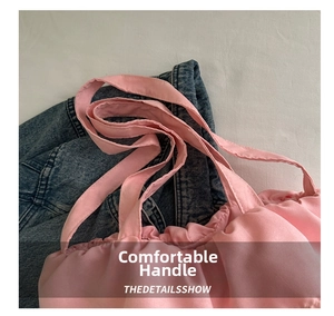 Close-up of pink ruffled tote bag featuring fabric handles and drawstring pleated details
