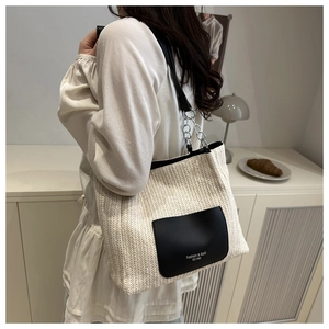 Dettaglio della borsa tote intrecciata con tasca in pelle nera e tracolla a catena