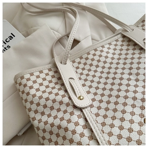 Détail du sac cabas floral montrant le cuir de qualité et les rivets dorés
