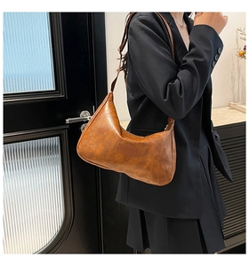 Detail of a brown faux leather hobo bag showing the embossed Fashion logo label