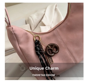 Detailed shot of pink suede tote bag featuring a novelty pretzel and abacus keychain