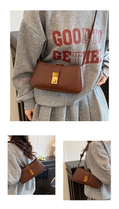 Detailed view of dark brown leather shoulder bag featuring a gold rectangular metal clasp