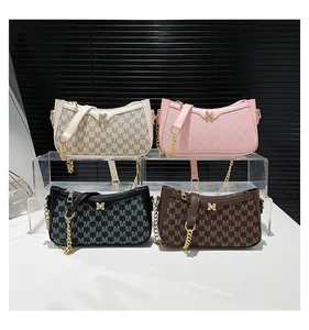 Detailed display of four textured crescent armpit bags with M logo and gold chain straps