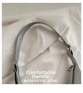 Detail of adjustable gray leather strap with silver metal buckle on a shoulder bag