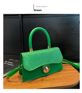 Détail du sac vert pailleté avec corps en cuir lisse et fermoir rotatif en métal doré