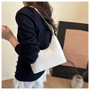 Minimalist white crescent underarm bag shown on shoulder for a stylish modern look