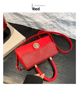 Détail du sac à paillettes rouges avec fermoir doré et poignée sur bois sombre