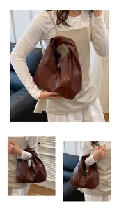 Détail du sac hobo en cuir marron foncé au design minimaliste avec une seule poignée