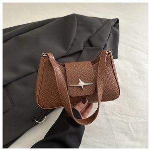 Close-up of brown textured shoulder bag featuring woven pattern and silver star buckle