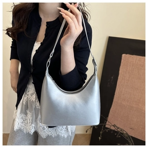 Close-up of metallic silver crescent hobo bag with sleek zipper and smooth finish