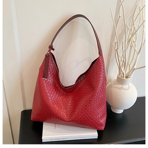 Macro view of the red woven leather texture and Intrecciato craft on this luxury tote bag