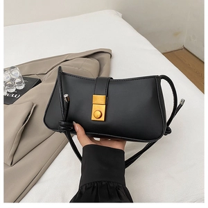 Detail of black leather underarm bag with golden square lock and woven rope shoulder strap