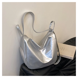 Detailed close-up of metallic silver pleated tote bag featuring zipper pocket and strap