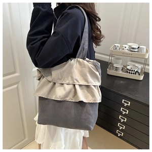 Detail of ruffle trim and grey-beige patchwork on a large suede-like tote bag
