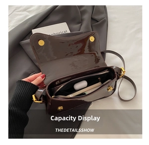 Vista interior del bolso de charol marrón con espacio para móvil y auriculares