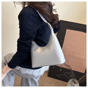 Detail of silver metallic hobo bag worn as a shoulder bag on a female model