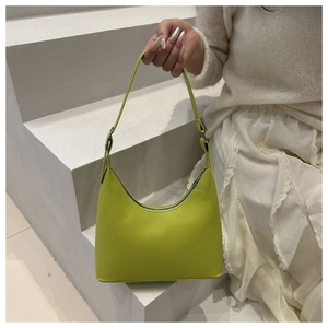 Detail of vibrant green dumpling bag with silver zipper and adjustable metal buckle strap