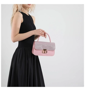 Detail of pink leather handbag featuring a glitter flap and golden CD metallic buckle