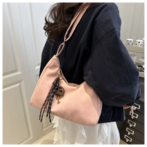 Detail view of pink suede tote bag featuring weave rope and metal key charm decor