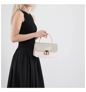 Detail of elegant pink handbag with silver glitter flap and gold twist lock closure
